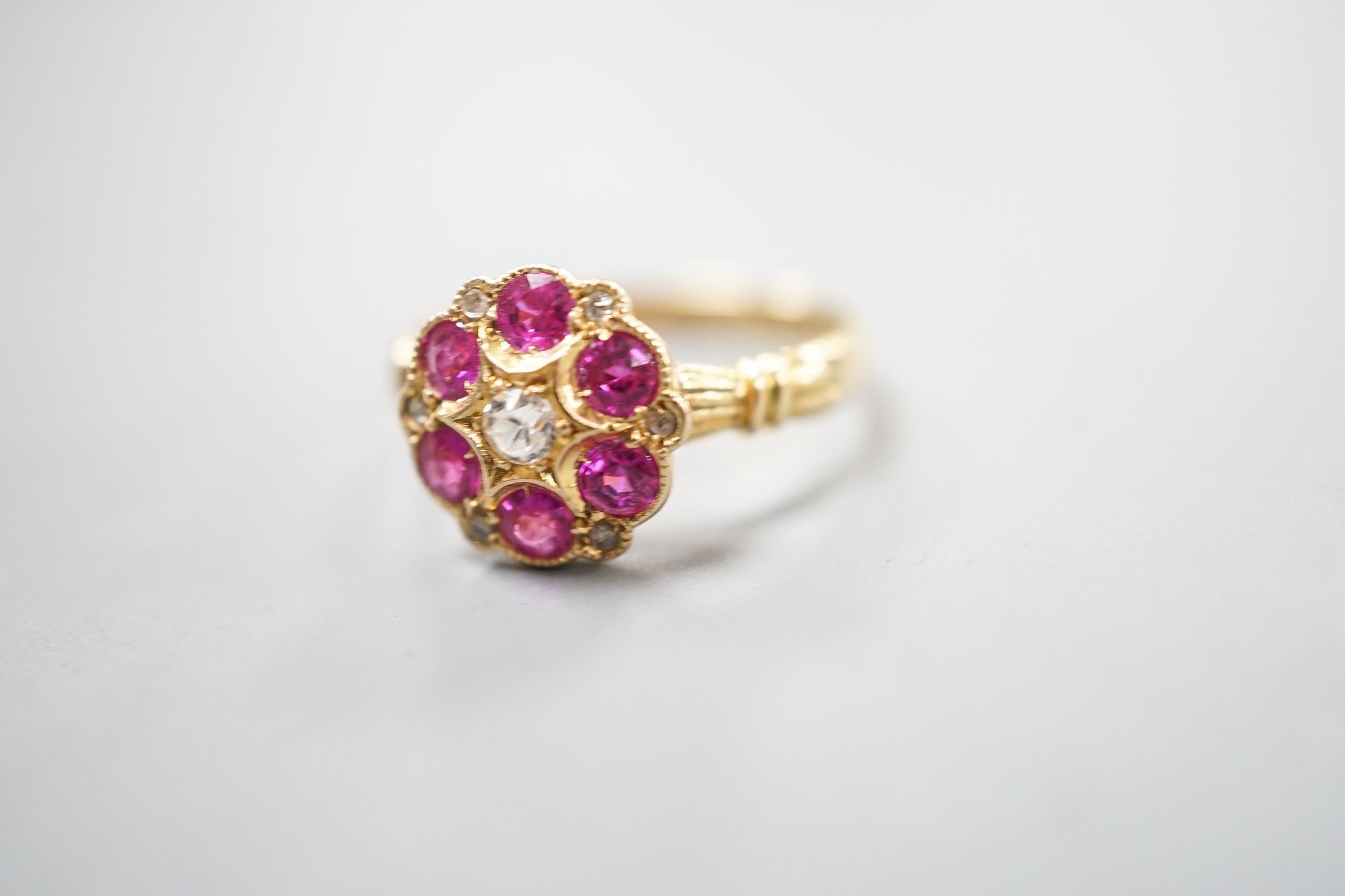 A George V 18ct gold, synthetic ruby, white sapphire? and diamond chip set cluster ring, size K, gross weight 2.4 grams.